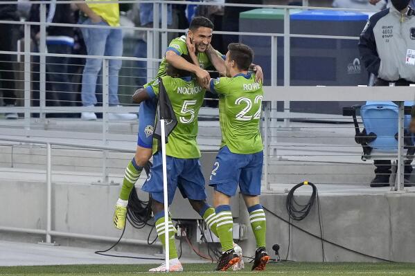 Seattle Sounders midfielder Cristian Roldan, top, celebrates with Nouhou Tolo (5) and Kelyn Rowe (22) after scoring a goal against the San Jose Earthquakes during the first half of an MLS soccer match Wednesday, May 12, 2021, in San Jose, Calif. (AP Photo/Tony Avelar)