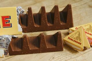 In this photo illustration two bars of the Toblerone Swiss chocolate are shown, at front is the new style 150 gram bar showing the reduction in triangular pieces, in the background is the older style 360 gram bar, pictured in London, Tuesday, Nov. 8, 2016. More valleys, fewer chocolate peaks: The maker of Toblerone Swiss chocolate says it's widened the spaces in its iconic, triangle-array bars for some discount shops in Britain to keep prices down. Mondelez International says the move aims to meet pricing targets by customer Poundland and other discount retailers, and has nothing to do with Britain's vote to leave the European Union. (AP Photo/Alastair Grant)