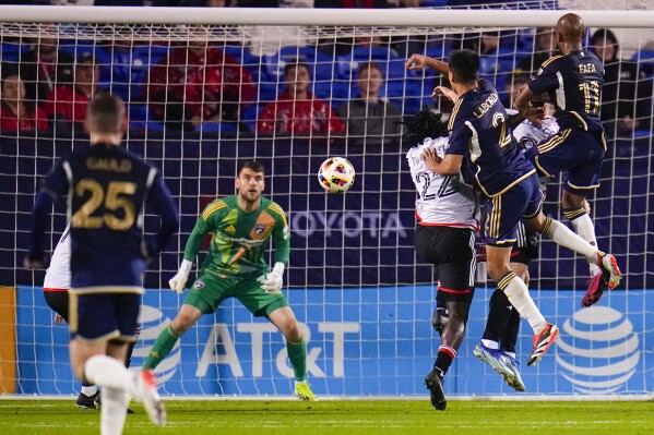Vancouver Whitecaps' Fafa Picault (11) heads the ball in for a goal against FC Dallas goalkeeper Maarten Paes, second from left, during the first half of an MLS soccer match, Saturday, March 16, 2024, in Frisco, Texas. (AP Photo/Julio Cortez)