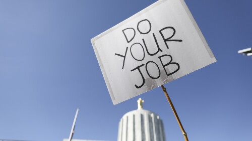 FILE - An attendee holds up a sign during a rally calling for an end to the Senate Republican walkout at the Oregon State Capitol in Salem, Ore., on May 11, 2023. Oregon lawmakers have been rushing to approve hundreds of bills and a budget for the next two years before the legislative session ends on Sunday, June 25, 2023. The bills were stalled by the six-week Republican walkout that ended last week. (AP Photo/Amanda Loman, File)
