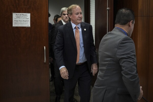 Texas Attorney General Ken Paxton, center, leaves the 185th District Court after a hearing in his securities fraud case, Friday, Feb. 16, 2024, at the Harris County criminal courthouse in Houston. A judge on Friday rejected Paxton’s attempts to throw out felony securities fraud charges that have shadowed the Republican for nearly a decade. (Jon Shapley/Houston Chronicle via AP)