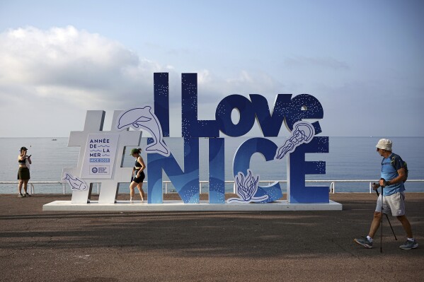 People walk on the sea promenade ahead of the UN Ocean Conference, Saturday, June 7, 2025 in Nice, French Riviera. (AP Photo/Laurent Cipriani)