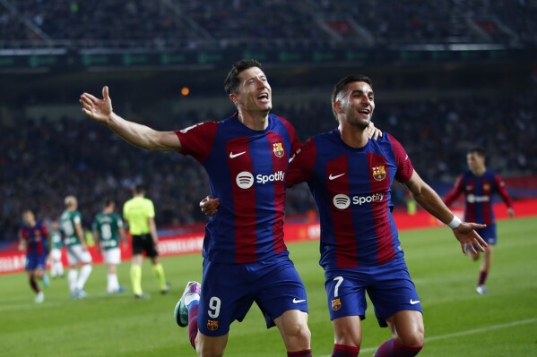 Barcelona's Robert Lewandowski celebrates scoring his side's second goal during the Spanish La Liga soccer match between Barcelona and Alaves at the Montjuic stadium in Barcelona, Spain, Sunday Nov. 12, 2023. (AP Photo/Joan Monfort)