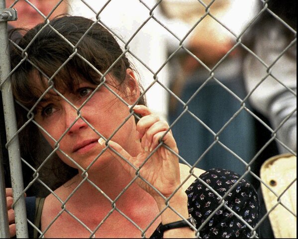 Karen Ellison looks through a chain link fence at a memorial service for rescue workers and volunteers at the Alfred P. Murrah Federal Building in Oklahoma City on May 5, 1995. (AP Photo J. Pat Carter, File)