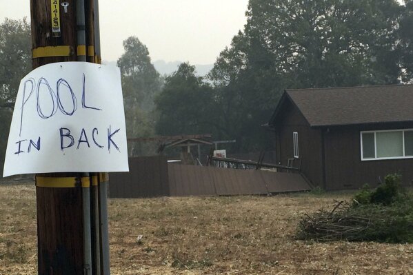 
              A residence in the hills above Sonoma, Calif., has a posted sign alerting people to an available pool if needed to shelter from wildfires Friday, Oct. 13, 2017. Stories of some people who lived through the inferno by standing in backyard swimming pools this week is spreading. (AP Photo/Ellen Knickmeyer)
            