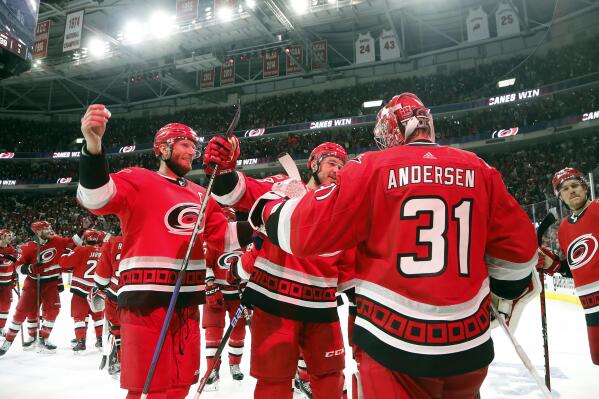 Carolina Hurricanes goaltender Frederik Andersen (31) is congratulated by Jordan Staal, left, and Mackenzie MacEachern, center, on the team's overtime win against the New Jersey Devils in Game 5 of an NHL hockey Stanley Cup second-round playoff series in Raleigh, N.C., Thursday, May 11, 2023. (AP Photo/Karl B DeBlaker)