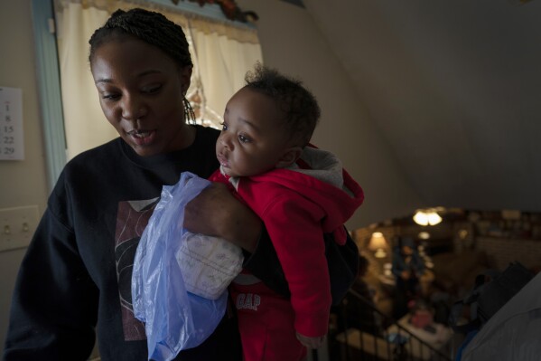 FILE - Ansonia Lyons carries her son, Adrien Lyons, as she takes him for a diaper change in Birmingham, Ala., on Saturday, Feb. 5, 2022. After two miscarriages, Ansonia became pregnant in 2020, and it was difficult. Doctors initially told her she was suffering from regular morning sickness, though she was vomiting blood. Ultimately, she was diagnosed with an excessive vomiting disorder. A study published Monday, July 3, 2023, in the Journal of the American Medical Association shows maternal mortality rates in the U.S. doubled between 1999 and 2019, that Native American and Alaskan Native populations had the largest rate increase and that, overall, Black maternal mortality rates were the highest. (AP Photo/Wong Maye-E, File)