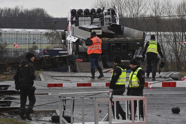 Policemen and railway inspectorate staff work at the scene of a train crash where a fast train collided with a truck at a level crossing in Dolni Lutyne near Karvina, Czech Republic, Wednesday, Jan, 24. 2024. A fast train collided with a truck in eastern Czech Republic on Wednesday, killing one person and injuring at least 19 people, officials said. The accident occurred early in the morning when a fast train heading for Prague, the country’s capital, hit a truck at a crossing near the town of Bohumin. (Jaroslav Ozana/CTK via AP)