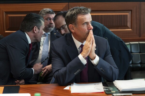 This image released by the White House and digitally altered to diffuse papers by the source for national security reasons, shows CIA Director John Ratcliffe, in foreground seated, as Defense Secretary Pete Hegseth, left, speaks with national security adviser Andy Baker with White House counsel David Warrington seated in background in the Situation Room, Saturday, June 21, 2025, at the White House in Washington. (The White House via AP)
