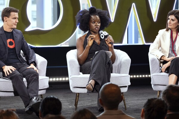 Hugh Evans, CEO of Global Citizen, left, listens as Actor Danai Gurira, center, addresses attendees of the Global Citizen Now conference, Wednesday, May 1, 2024, in New York. Fran Katsoudas is right. (AP Photo/Craig Ruttle)