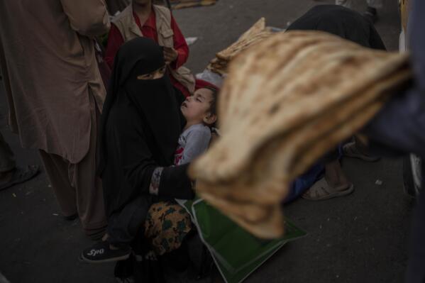 An Afghan woman begs at a market in Kabul's Old City, Afghanistan, Tuesday, Sept. 14, 2021. A month after the fall of Kabul, the question of how the world will get aid to citizens without enriching Afghanistan's Taliban rulers is haunting the country. The stakes have soared for Afghans, who along with the threat of famine and a collapsing health care system face a looming crisis as winter approaches. (AP Photo/Bernat Armangue)