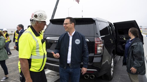 Gov. Josh Shapiro, right, talks with Robert Buckley, president Buckley & Co. during a news conference to announce the reopening of Interstate 95 Friday, June 23, 2023 in Philadelphia. Workers put the finishing touches on an interim six-lane roadway that will serve motorists during construction of a permanent bridge. (AP Photo/Joe Lamberti)