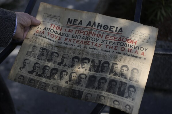 Author and historian Spyros Kouzinopoulos holds a newspaper announcing the Sept. 15, 1947, court ruling to execute 52 people being held at Yedi Kule prison, in Thessaloniki, Greece, Saturday, April 12, 2025. (AP Photo/Thanassis Stavrakis)