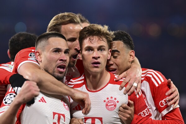 Bayern's Joshua Kimmich, centre, celebrates with teammates after scoring his side's opening goal during the Champions League quarter final second leg soccer match between Bayern Munich and Arsenal at the Allianz Arena in Munich, Germany, Wednesday, April 17, 2024. (AP Photo/Christian Bruna)