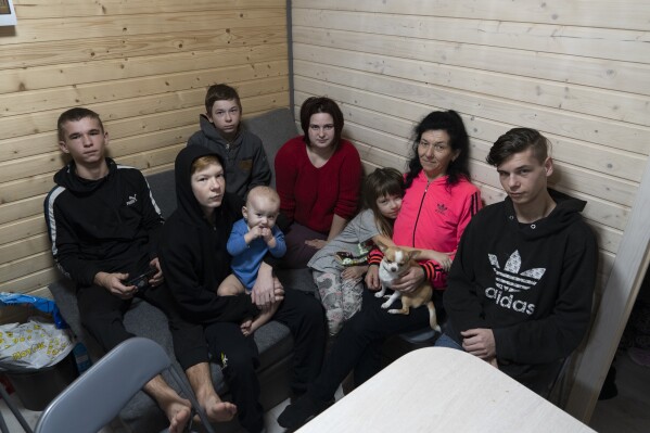 50-year-old Natalia Zhyvohliad, an internally displaced person from Nova Petrivka in the Zaporizhzhia region of Ukraine, is pictured with her children, daughter-in-law and grandson in their temporary modular house in Kolomyya, Ivano-Frankivsk region on Feb. 13, 2024. (AP Photo/Vasilisa Stepanenko)