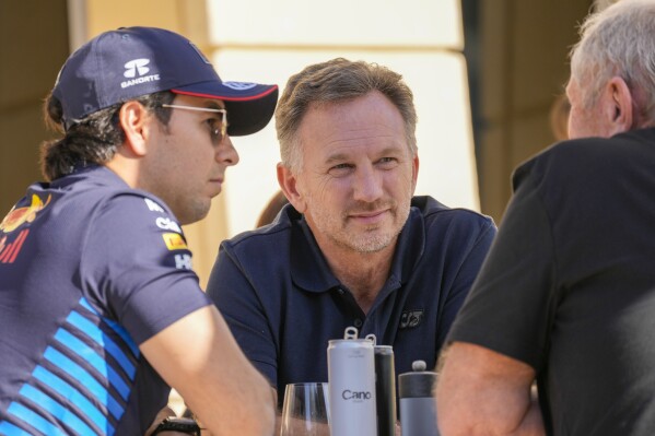 Red Bull team principal Christian Horner, centre, chats with Red Bull driver Sergio Perez of Mexico, left, and Helmut Marko, director of the Red Bull Formula One teams, right, at the pits during Formula One pre season test at the Bahrain International Circuit in Sakhir, Bahrain, Wednesday, Feb. 21, 2024. (AP Photo/Darko Bandic)