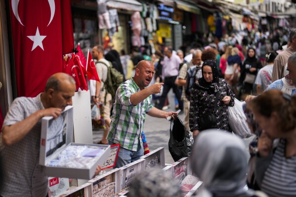 FILE - Sellers attend to customers in a street market in Eminonu commercial district in Istanbul, Turkey, on June 16, 2023. Turkey’s central bank raised its key interest rate on Thursday July 20, 2023 to 17.5% in a further sign of commitment to orthodox economic policy following elections in May. (AP Photo/Francisco Seco, File)