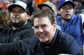 FILE - Actor Tom Cruise smiles during Game 2 of a baseball National League Division Series between the San Francisco Giants and the Los Angeles Dodgers Saturday, Oct. 9, 2021, in San Francisco. The Ohio State University marching band paid a tribute to the movie “Top Gun" during the Nov. 13, 2021, NCAA college football game against Purdue. On Tuesday, Dec. 28, the marching band tweeted that Cruise, the movie’s star, saw the halftime performance and offered a personal message thanking them, saying the “tribute was fantastic.” (AP Photo/Jeff Chiu, File)