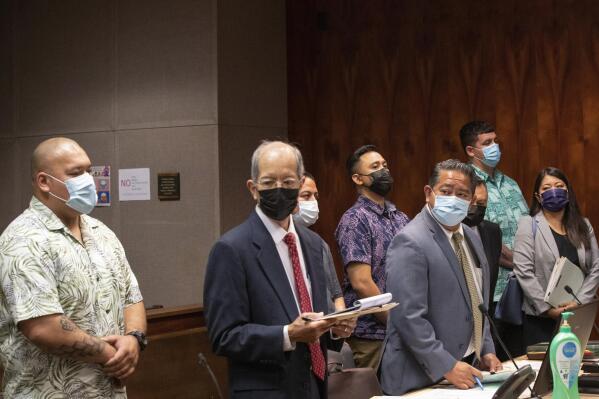 Honolulu Police Department police officers, back row left to right, Joshua Nahulu, Robert G. Lewis III, Jake R.T. Bartolome and Erik X.K. Smith make their initial court appearance in Honolulu on Thursday, March 23, 2023 with their attorneys, front left to right, Howard Luke, Benjamin Ignacio, Pedric Arrisgado and Doris Lum. The four Honolulu police officers face felony charges in connection with a September 2021 police pursuit that ended in a crash that the officers allegedly fled and conspired to cover up. The officers pleaded not guilty. (Cindy Ellen Russell/Honolulu Star-Advertiser via AP, Pool)