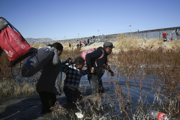 Migrants cross the Rio Grande River to reach the United States from Ciudad Juarez, Mexico, Wednesday, Dec. 27, 2023. (AP Photo/Christian Chavez)