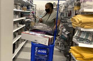 In this July 21, 2021 photo, a consumer shops as she wears a mask at a retail store in Morton Grove, Ill.  Americans kept shopping last month, despite a rise in COVID-19 cases. Retail sales rose a seasonal adjusted 0.7% in August from the month before, the U.S. Commerce Department said Thursday, Sept. 16.  (AP Photo/Nam Y. Huh)