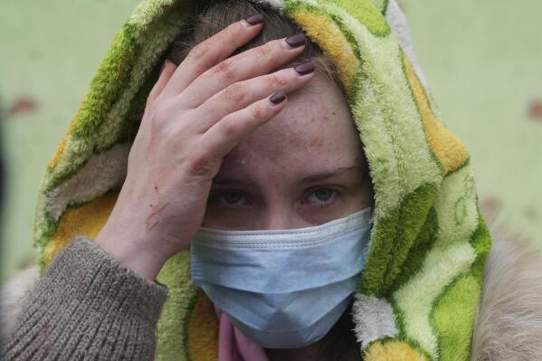 A woman walks outside the damaged by shelling maternity hospital in Mariupol, Ukraine, Wednesday, March 9, 2022. A Russian attack has severely damaged a maternity hospital in the besieged port city of Mariupol, Ukrainian officials say. (AP Photo/Evgeniy Maloletka)