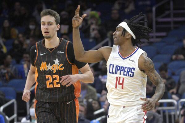 Los Angeles Clippers guard Terance Mann (14) celebrates after scoring a 3-pointer in front of Orlando Magic forward Franz Wagner (22) during the first half of an NBA basketball game, Wednesday, Jan. 26, 2022, in Orlando, Fla. (AP Photo/Phelan M. Ebenhack)