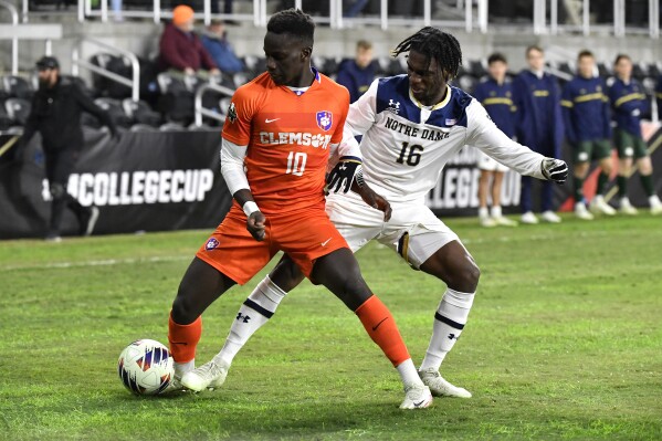 Clemson midfielder Ousmane Sylla (10) battles Notre Dame midfielder KK Baffour (16) for the ball during the first half of the NCAA college soccer tournament championship game in Louisville, Ky., Monday, Dec. 11, 2023. (AP Photo/Timothy D. Easley)