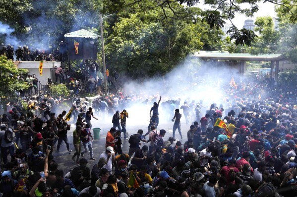 FILE - Police fire tear gas as protesters stormed the compound of Prime Minister Ranil Wickremesinghe demanding he resign after President Gotabaya Rajapaksa fled the country amid an economic crisis in Colombo, Sri Lanka, on July 13, 2022. (AP Photo/Eranga Jayawardena, File)