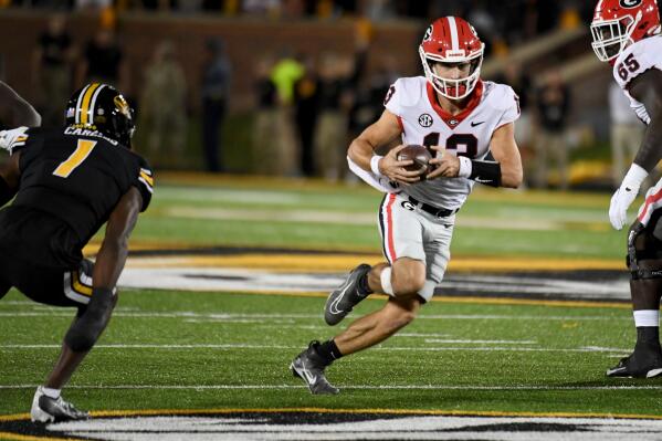 Georgia quarterback Stetson Bennett runs with the ball on a fake field goal attempt as Missouri defensive back Jaylon Carlies (10) defends during the first half of an NCAA college football game Saturday, Oct. 1, 2022, in Columbia, Mo. (AP Photo/L.G. Patterson)