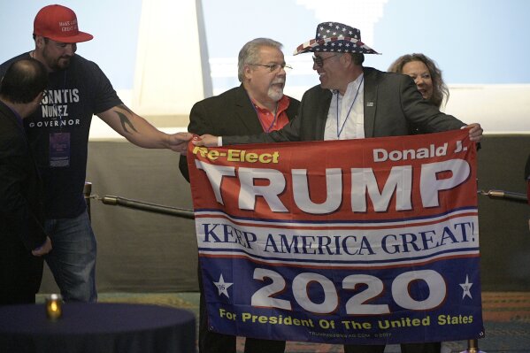 
              Supporters hold a sign for President Donald Trump during an election party for Florida Republican gubernatorial candidate Ron DeSantis, Tuesday, Nov. 6, 2018, in Orlando, Fla. (AP Photo/Phelan M. Ebenhack)
            