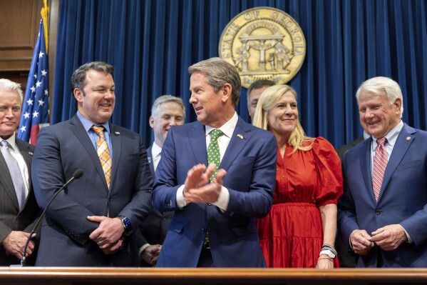 Thống đốc Georgia Brian Kemp vỗ tay sau khi ký luật cho phép một ủy ban kỷ luật và cách chức các công tố viên bắt đầu hoạt động tại Tòa nhà Quốc hội ở Atlanta vào Thứ Tư, ngày 13 tháng 3 năm 2024. Các nhà phê bình lo ngại luật này sẽ được sử dụng để nhắm vào vụ truy tố Fani Willis của Luật sư Quận Fulton của cựu Tổng thống Donald Trump. (Arvin Temkar/Tạp chí Atlanta-Hiến pháp qua AP)