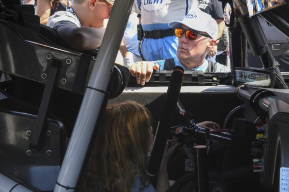 Driver Kevin Harvick visits with his children Keeland, left and Piper, before a NASCAR Cup Series auto race at Talladega Superspeedway, Sunday, Oct. 1, 2023, in Talladega, Ala. (AP Photo/Julie Bennett)