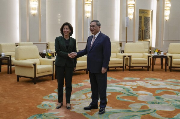 U.S. Commerce Secretary Gina Raimondo, left, shakes hands with Chinese Premier Li Qiang before their meeting at the Great Hall of the People in Beijing, Tuesday, Aug. 29, 2023. (AP Photo/Andy Wong, Pool)