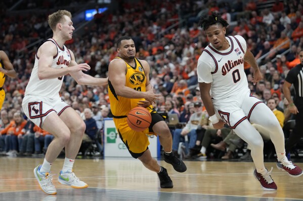 Missouri's Nick Honor, center, loses control of the ball as Illinois' Marcus Domask, left, and Terrence Shannon Jr. (0) defend during the second half of an NCAA college basketball game Friday, Dec. 22, 2023, in St. Louis. (AP Photo/Jeff Roberson)