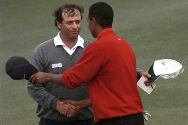 FILE - Masters champion Tiger Woods is congratulated by his playing partner Costantino Rocca, left, after their final round of the Masters in Augusta, Ga., on April 13, 1997. A 60-foot birdie putt sunk on the 18th at St. Andrew’s before a playoff loss to John Daly at the 1995 British Open. A front-row seat to history paired with Tiger Woods in the final round of the 1997 Masters. Then a career-defining singles win over Woods later in ’97 that helped Europe win the Ryder Cup. It’s been nearly three decades since Costantino Rocca put Italian golf on the map and it’s hard to imagine the Ryder Cup being held near Rome this week would have happened without him. (AP Photo/Amy Sancetta, File)