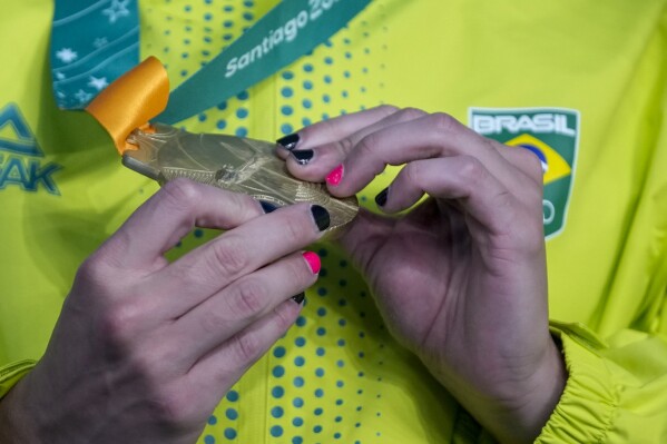 Brazil's Felipe Ribeiro holds his gold medal at the the podium of the men's 4x100-meters freestyle relay at the Pan American Games in Santiago, Chile, Saturday, Oct. 21, 2023. Brazil won the gold medal. (AP Photo/Fernando Vergara)