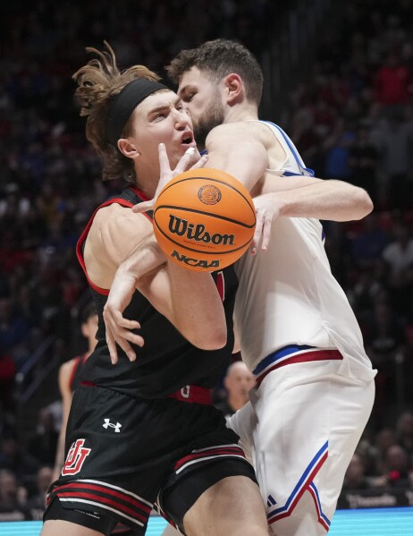 Kansas center Hunter Dickinson (1) fouls Utah center Lawson Lovering (34) during the second half of an NCAA college basketball game, Saturday, Feb. 15, 2025, in Salt Lake City. (AP Photo/Bethany Baker)