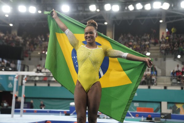 Brazil's Rebeca Andrade celebrates with her national flag after winning gold in the women's gymnastics vault exercise final at the Pan American Games in Santiago, Chile, Tuesday, Oct. 24, 2023. (AP Photo/Martin Mejia)