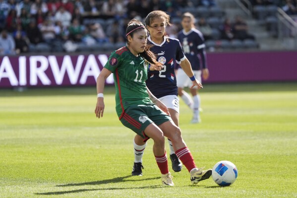 CORRECTS ID TO LIZBETH NOT JACQUELINE - Mexico midfielder Lizbeth Ovalle, left, passes in front of Paraguay defender Limpia Fretes during the first half of a CONCACAF Gold Cup women's soccer tournament quarterfinal, Sunday, March 3, 2024, in Los Angeles. (AP Photo/Marcio Jose Sanchez)