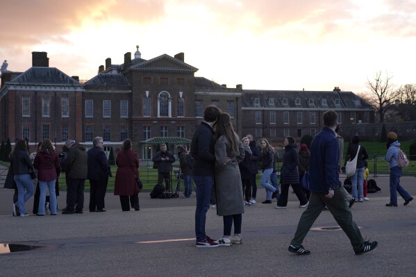 People stand in front of Kensington Palace in London, Friday, March 22, 2024. Kensington Palace contains the offices and London residences of The Prince and Princess of Wales. Kate, Princess of Wales, says she has cancer and is undergoing chemotherapy. (AP Photo/Alberto Pezzali)