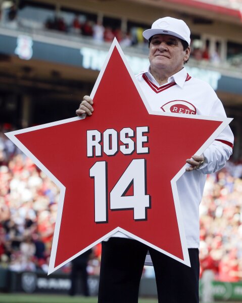 FILE -In this June 24, 2016, file photo, former Cincinnati Reds player Pete Rose (14) holds his place marker during a ceremony to honor the 1976 World Series champion team, before the Reds' baseball game against the San Diego Padres in Cincinnati. Rose once again asked Major League Baseball to end his lifetime ban, saying the penalty is unfair compared with discipline for steroids use and electronic sign stealing. Rose's lawyers submitted the application Wednesday, Feb. 5, 2020, to baseball Commissioner Rob Manfred, who in December 2015 denied the previous request by the career hits leader. (AP Photo/John Minchillo, File)
