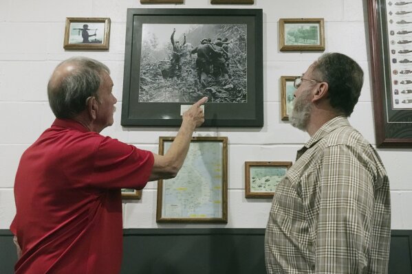 
              This Friday, Oct. 27, 2017 photo shows Vietnam veteran Dallas Brown, left, pointing to himself in a Vietnam War-era photo in Fort Campbell, Ky. Fellow veteran Tim Wintenburg is at the far right in the iconic war photo, which was taken by Associated Press freelancer Art Greenspon on April 1, 1968, nearly 50 years ago. The photo was on the front page of the New York Times and was nominated for a Pulitzer Prize. Brown and Wintenburg recently visited Fort Campbell to talk about the photo and the war. (AP Photo/Dylan Lovan)
            