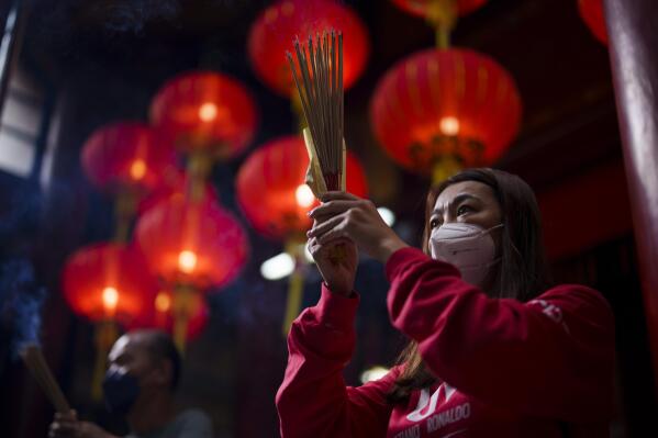 A Malaysian ethnic Chinese prays on the first day of the Lunar New Year celebrations at a temple in Kuala Lumpur, Malaysia, Sunday, Jan. 22, 2023. The Chinese Lunar New Year begins on Jan. 22, marking the start of the Year of the Rabbit, according to the Chinese zodiac. (AP Photo/Vincent Thian)