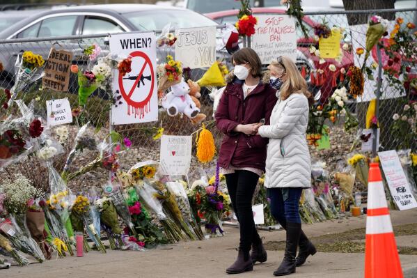 FILE - Mourners walk along the temporary fence put up around the parking lot of a King Soopers grocery store where a mass shooting took place earlier in the week, Thursday, March 25, 2021, in Boulder, Colo. The Board of Commissioners of Boulder County, Colo., gave initial approval on Tuesday, July 5, 2022, to new county-wide gun control ordinances that would exceed both state and federal regulations. (AP Photo/David Zalubowski, File)