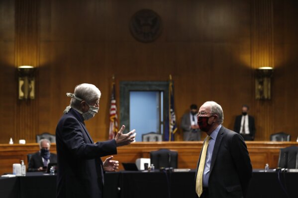 FILE - In this Thursday, May 7, 2020 file photo, National Institutes of Health Director Dr. Francis Collins, left, speaks with Chairman Sen. Lamar Alexander, R-Tenn., prior to a Senate Health Education Labor and Pensions Committee hearing on new coronavirus tests on Capitol Hill in Washington.  Collins has lauded the majority of American faith communities for treating the pandemic as an opportunity to live out their values by helping the vulnerable. He also offered careful criticism for the “occasional examples of churches who reject the scientific conclusions and demand the right to continue to assemble freely, even in the face of evidence that this endangers their whole community.”(AP Photo/Andrew Harnik, Pool)