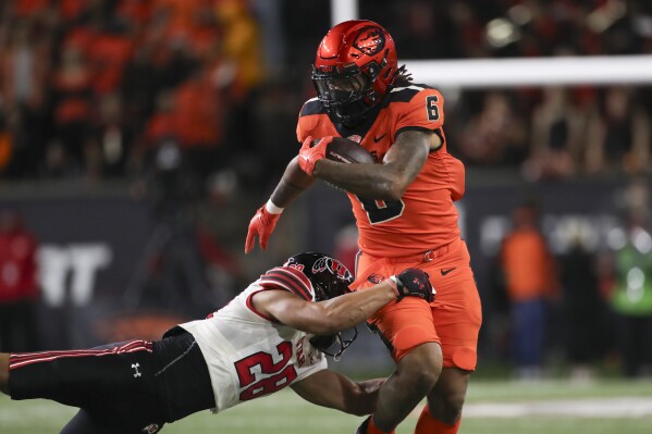 Oregon State running back Damien Martinez (6) is brought down by Utah safety Sione Vaki (28) during the second half of an NCAA college football game Friday, Sept. 29, 2023, in Corvallis, Ore. Oregon State won 21-7. (AP Photo/Amanda Loman)