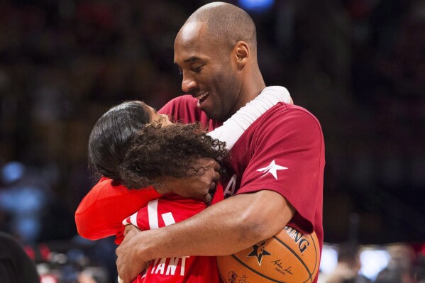 In this Feb. 14, 2016, file photo, Los Angeles Lakers Kobe Bryant (24) hugs his daughter Gianna on the court in warm-ups before first half NBA All-Star Game basketball action in Toronto. Bryant, his 13-year-old daughter, Gianna, and several others are dead after their helicopter went down in Southern California on Sunday, Jan. 26, 2020. (Mark Blinch/The Canadian Press via 番茄直播)