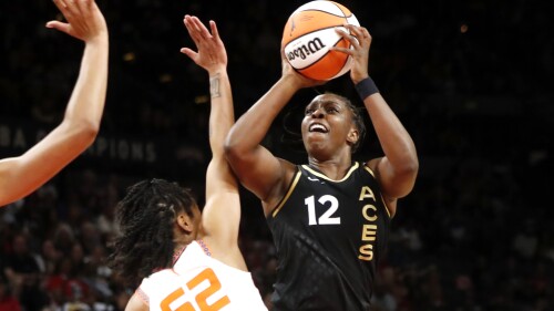 Las Vegas Aces guard Chelsea Gray (12) takes a shot over Connecticut Sun guard Tyasha Harris (52) during the first half of a WNBA basketball game Saturday, July 1, 2023, in Las Vegas. (Steve Marcus/Las Vegas Sun via AP)