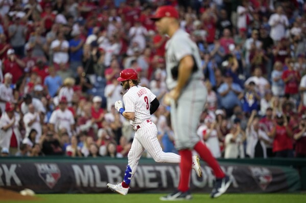 Philadelphia Phillies' Bryce Harper, left, rounds the bases after hitting a home run against Los Angeles Angels pitcher Tyler Anderson during the second inning of a baseball game, Tuesday, Aug. 29, 2023, in Philadelphia. (AP Photo/Matt Slocum)